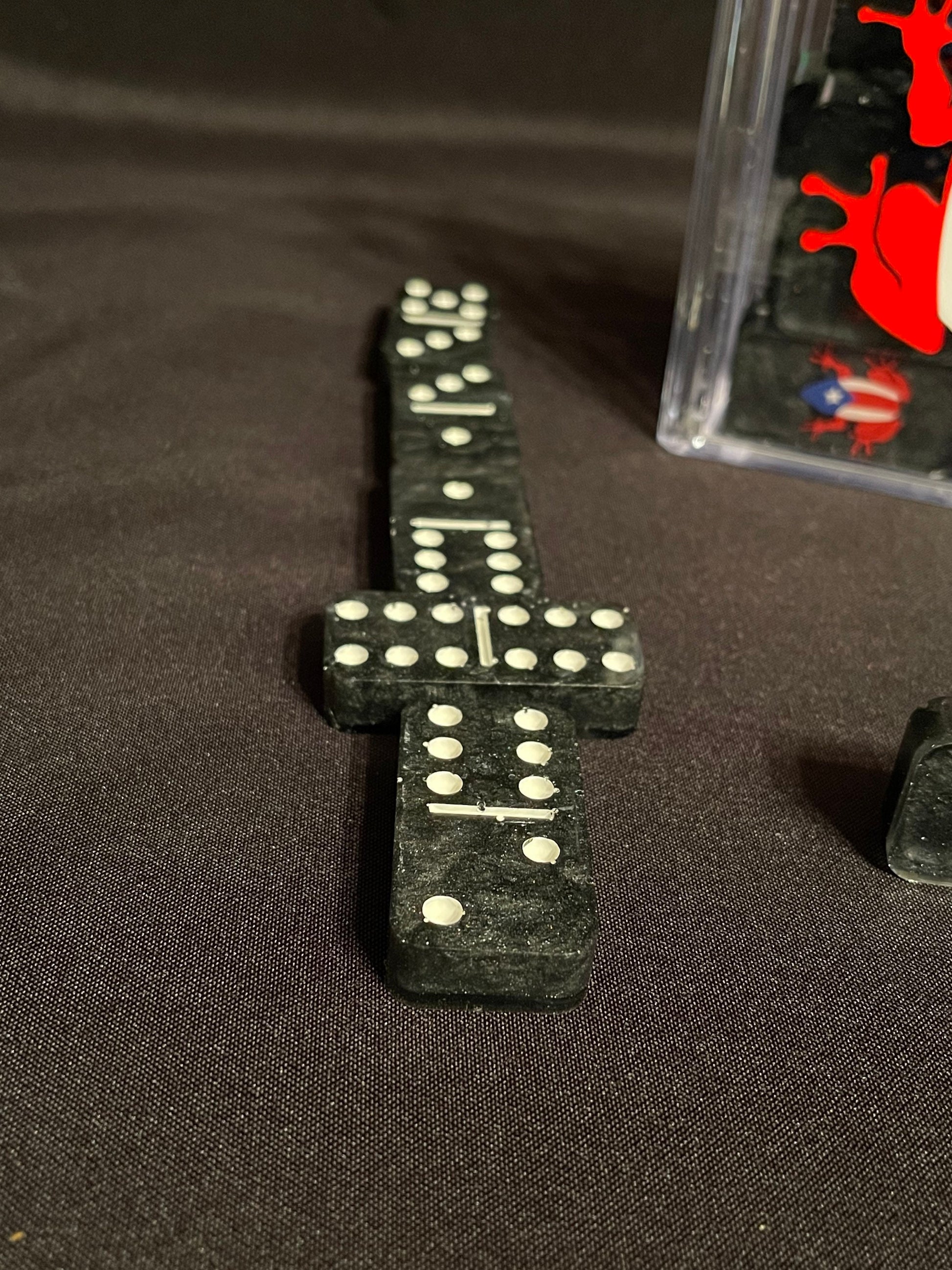 Black set of Coqui dominoes showing the dots and lines