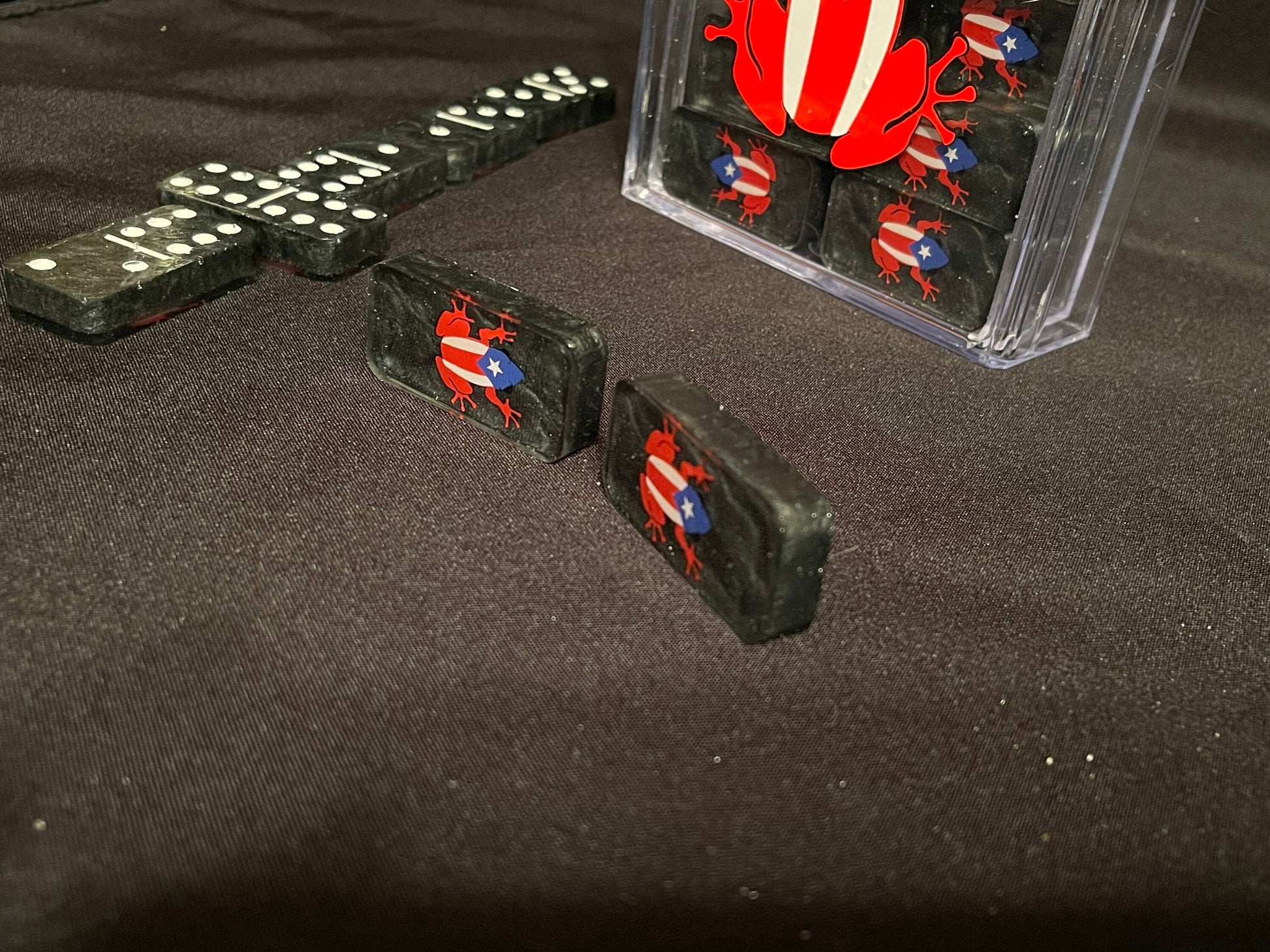Black set of Coqui dominoes showing off the dots and lines and the design as well as the box.