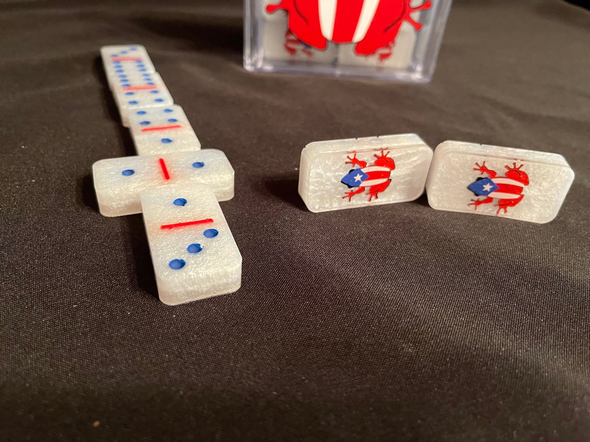 White set of dominoes showing off the dots painted in blue and lines in red and then design on 2 dominoes