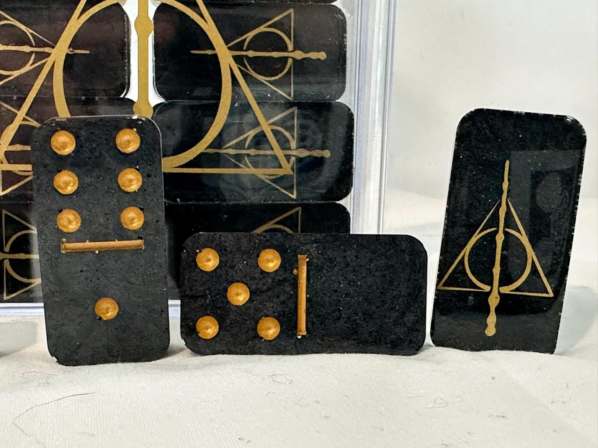 Closeup of the Deathly Hallows dominoes showing the dots, lines, and design all in gold