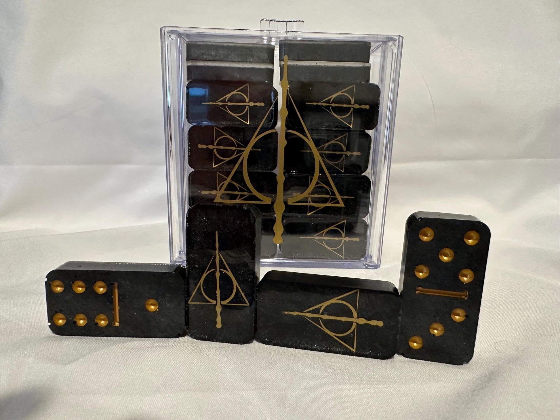 Deathly Hallows dominoes being shown off with the design on the dominoes and the case as well as the dots and lines of the dominoes