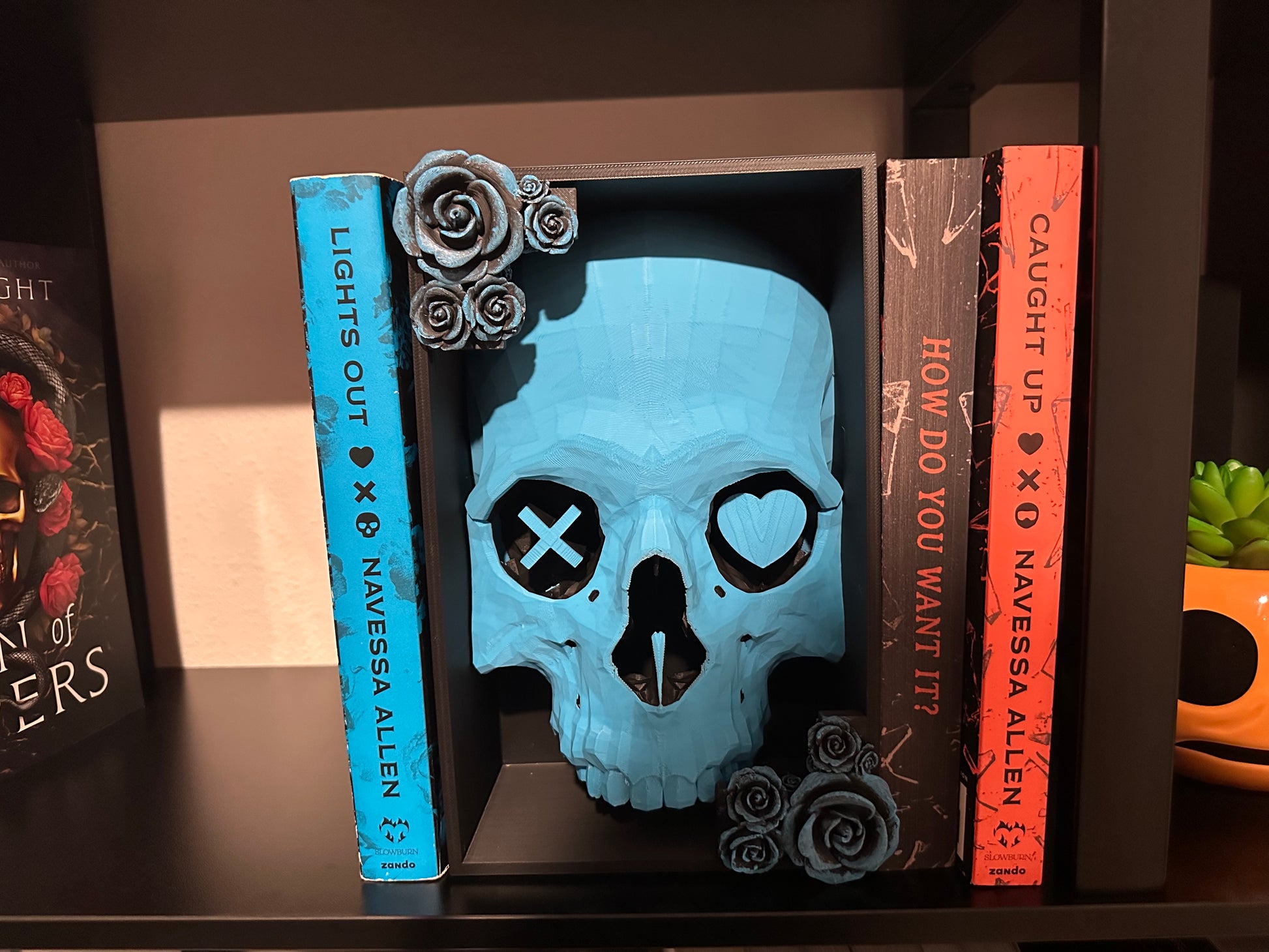 The full skull design displayed on a bookshelf with books