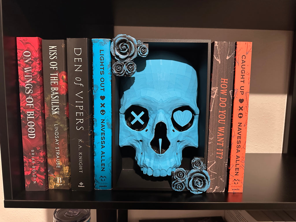 Full skull on bookshelf with some books displayed