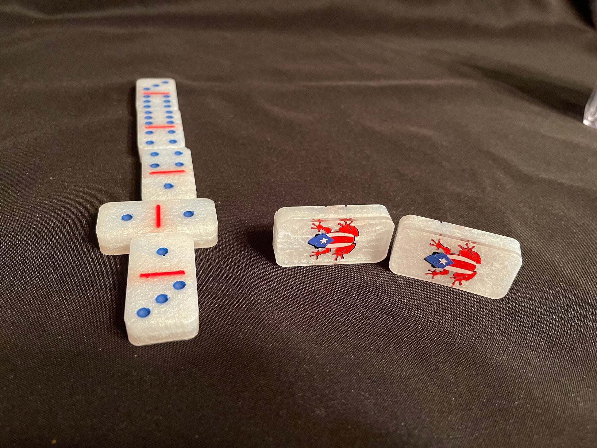 White set of Coqui Dominoes showcasing multiple color dots and lines and the design